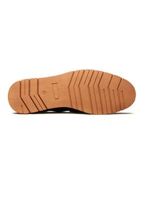 Black shoe sole with a textured rubber surface, featuring a prominent tread pattern and a light tan color along the bottom edge.