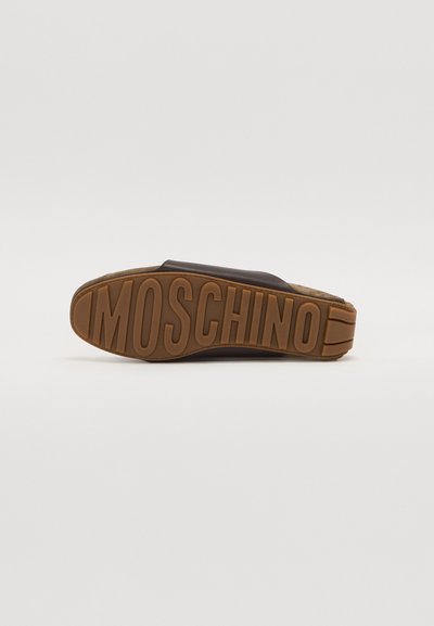 Tumepruun libisemise sandaal kummist tallaga, millel on reljeefne "MOSCHINO" brändingu logo. Pehme tekstuur ja minimaalne disain.