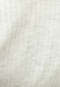 Světlá látka s vertikálním pruhovaným vzorem, která má jemnou strukturu a měkký, hladký povrch.