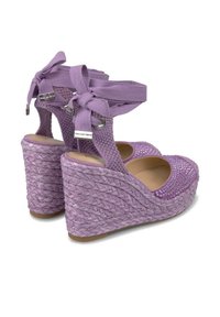 Sandales compensées violettes avec texture en corde tissée, liens de cheville en tissu ajustables et empeigne ornée de détails scintillants et de découpes.