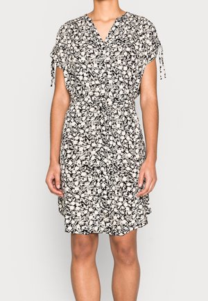 Blomstret kjole i sort og creme, med v-udskæring, korte ærmer og snoretræk i taljen. Blødt, let stof med en løs pasform.