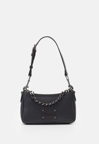 Sac à main en similicuir noir avec une silhouette courbée, des accents en chaîne et sangle, et une plaque logo métallique à l'avant.