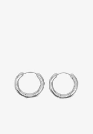 Para srebrnych kolczyków typu koło z teksturowanym, lekko nieregularnym zaokrąglonym wzorem i cienkimi zamknięciami na drucik.