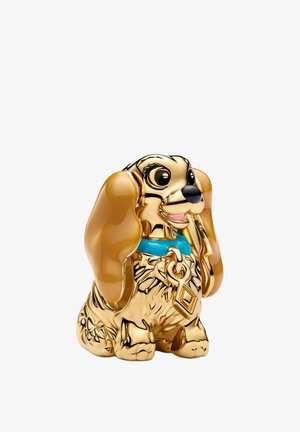 Figurine de chien dorée et marron avec de grandes oreilles, un collier bleu et un pendentif en forme de clé, assise et regardant devant avec une expression souriante.