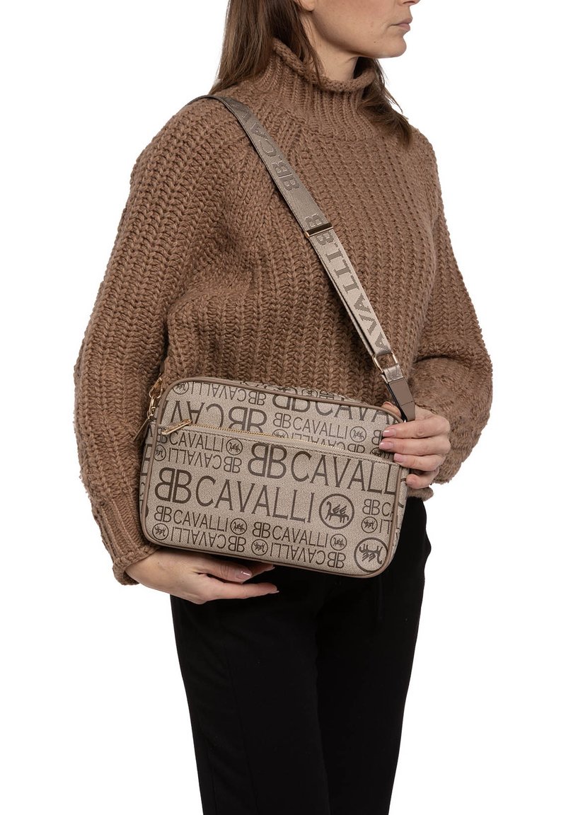 Borsa a tracolla beige con una texture liscia, caratterizzata da un motivo ripetuto del logo e una tracolla regolabile. Chiusura a zip con accenti metallici.