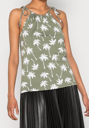 Top na szyję w kolorze oliwkowej zieleni z białym nadrukiem palm; posiada regulowane wiązania na ramionach i luźny krój. Połączony z plisowaną czarną spódnicą.