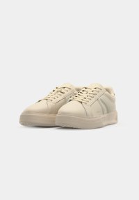 Sneaker beige con tomaia sintetica liscia, punta rotonda, lacci piatti e suola in gomma testurizzata con motivo a diamante.