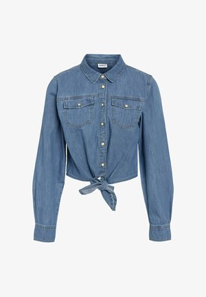 Plava traper košulja skraćenog kroja s dugim rukavima, prednjim kopčanjem na gumbe, dva džepa na prsima i detaljem čvora na rubu. Klasični ovratnik.