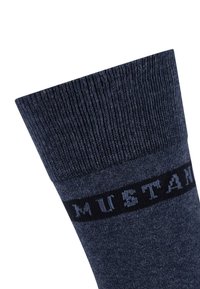 Calza lavorata a maglia di un blu scuro con orlo a coste, caratterizzata da una fascia nera a contrasto che riporta la parola "MUSTANG" in lettere azzurro chiaro.