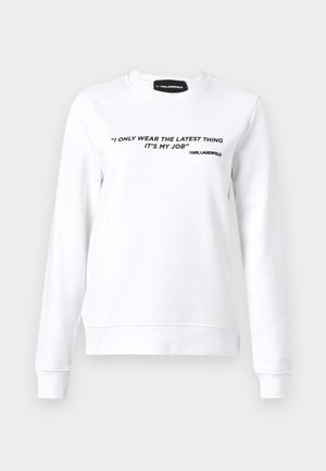 White sweatshirt in cotton blend, features long sleeves and crew neck. Black text on front reads, “I ONLY WEAR THE LATEST THING IT’S MY JOB.”
