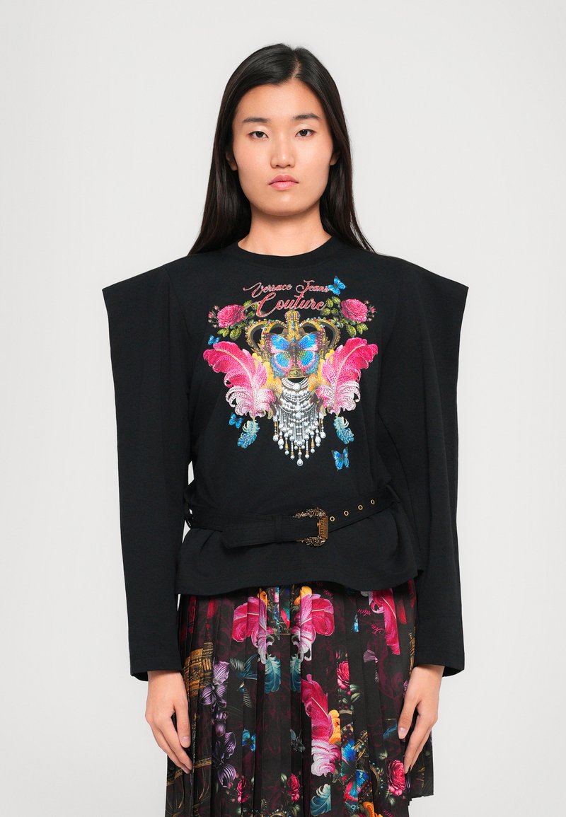 Zwarte longsleeve top met gestructureerde schouders, versierd met kleurrijke bloemen- en vlinderborduursels, en cinched in de taille met een decoratieve riem.