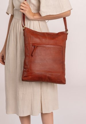 Bolsa tote de cuero marrón con una superficie texturizada, forma rectangular, correa de hombro ajustable y un bolsillo frontal con cremallera.