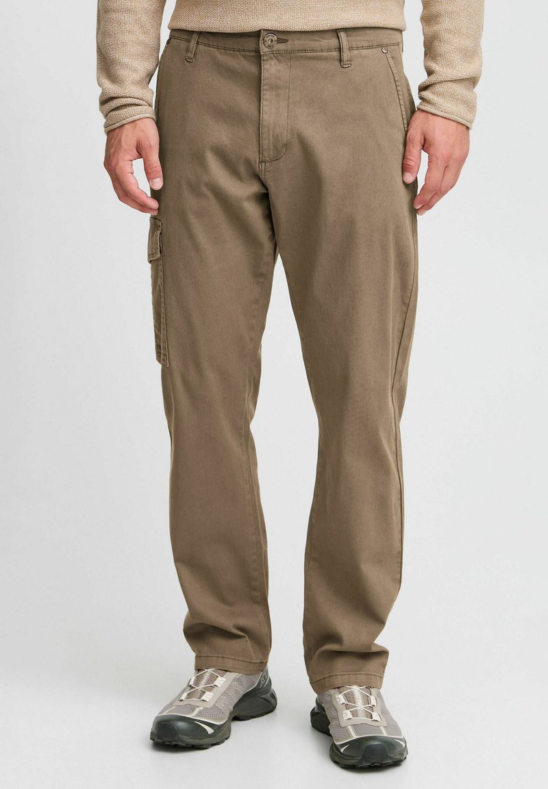 Brown cargo pants made of durable fabric. Features a zip fly, belt loops, and a side cargo pocket. Tapered fit with clean lines.