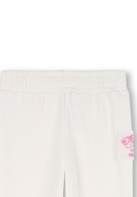 Weiße Jogginghose mit geripptem Bündchen, Seitentaschen und einem Stoffpatch mit pinkem Grafikdesign. Glatte Textur, lässige Passform.
