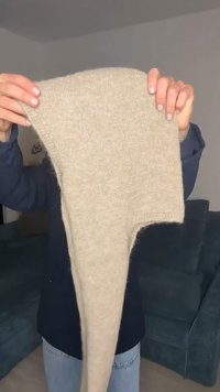 Beež värvusega kootud kangas, mis on drapeeritud pika ja ebaühtlase kujuga. Pehme tekstuur kerge karvasusega, näidates puhast äärt ja sujuvat viimistlust.