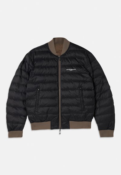 Jachetă bomber neagră, matlasată, cu manșete, guler și tiv din țesătură maro, fermoar frontal, buzunare laterale cu fermoar și logo alb Emporio Armani pe piept.