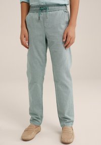 Světle tyrkysové jogger kalhoty s elastickým pasem a šňůrkou na stažení. Vyrobeny z měkké, lehké tkaniny. Obsahují boční kapsy a zúžený střih.