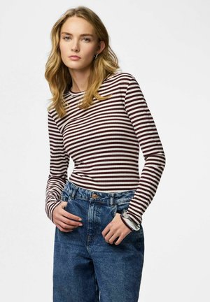 Haut à manches longues rayé en bordeaux et crème, associé à un jean en denim bleu taille haute, avec une coupe décontractée et une fermeture boutonnée.