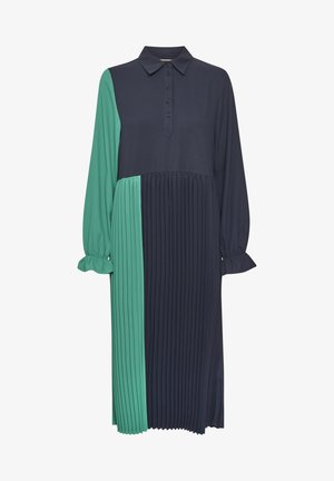 Kostková košile šaty s dlouhými rukávy. Obsahuje zelené a námořnické barevné bloky, sklady na jedné straně a knoflíkový detail na límci.