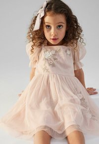 Rosa Tüllkleid mit kurzen Puffärmeln, verziert mit floraler Stickerei und einem gerafften Rock. Ein passendes Band schmückt das Haar.