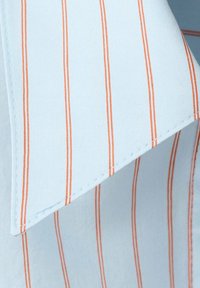 Tissu bleu clair avec des rayures orange verticales régulièrement espacées et un pli d'angle pointu.