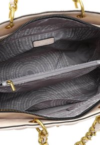 Borsa a tracolla beige con hardware dorato, chiusura con zip e tasca interna con zip. Foderata con un tessuto grigio a motivo con logo.