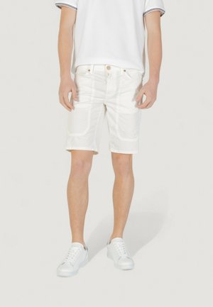 Pantalones cortos de algodón blancos con un corte ajustado, que cuentan con bolsillos laterales y una textura suave. Combinados con zapatillas blancas y una camisa blanca.
