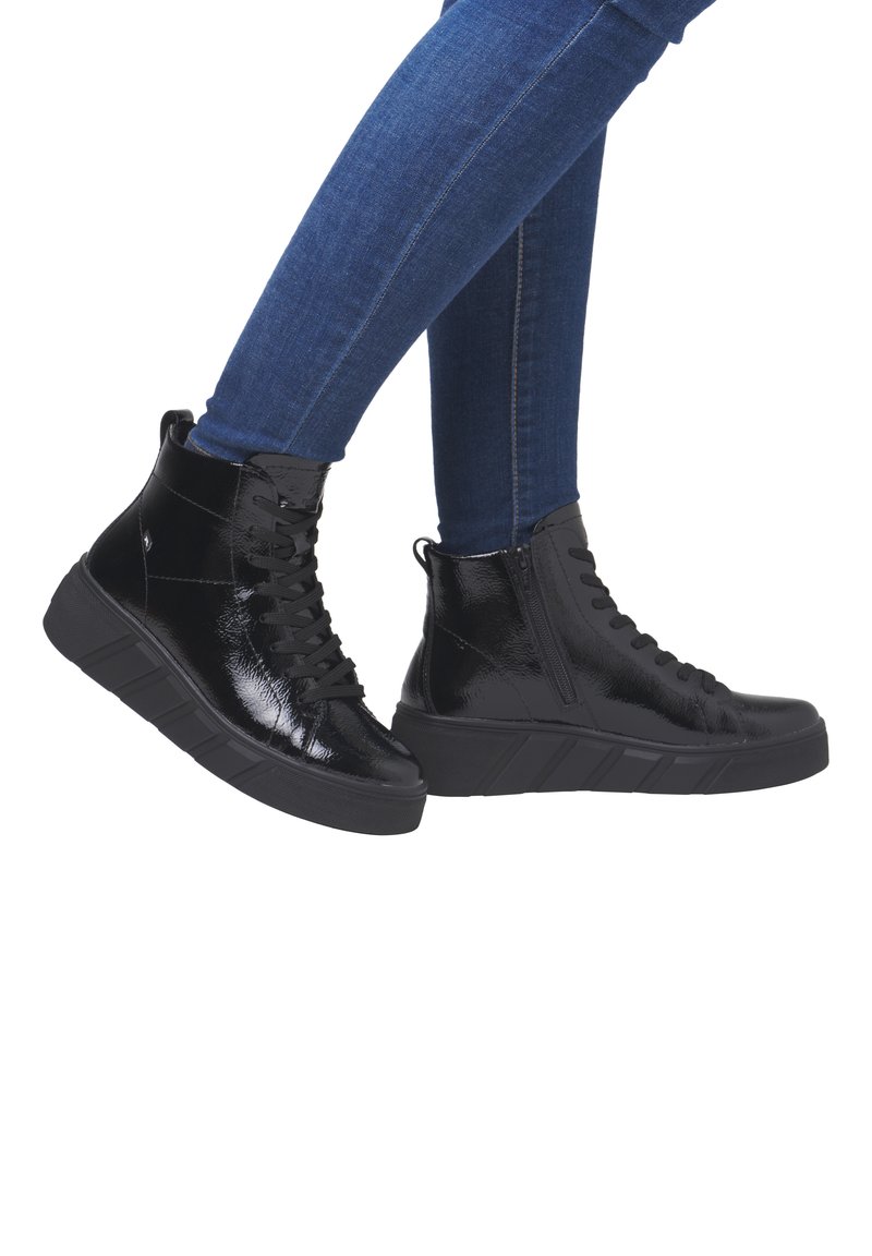 Chaussures montantes en cuir verni noir avec bout rond, fermeture à lacets à l'avant et fermeture éclair sur le côté, dotées d'une semelle épaisse et d'accents texturés.