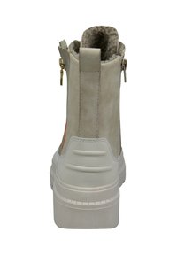 Botín de ante gris claro con suela de goma blanca, detalle de cremallera y forro suave. Presenta un acento naranja en el tacón.