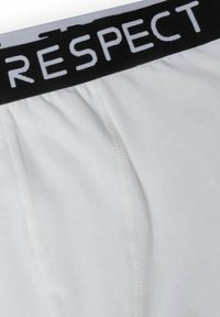Fehér boxer alsónadrág fekete elasztikus derékrésszel, amelyen fehér betűkkel a "TISZTELET" szó látható. Puha anyag, sima textúrával.
