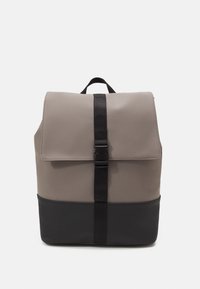 Sac à dos avec un dessus gris et un fond noir, fabriqué en matériau lisse. Comprend un rabat de fermeture, une sangle verticale et une poignée de transport.
