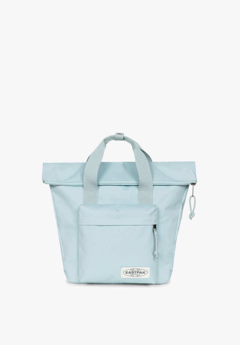 Světle modrá taška přes rameno s dvěma uchy, sklápěcí vršek, přední kapsa na zip a tkaná cedulka. Hladká textura a minimalistický design.