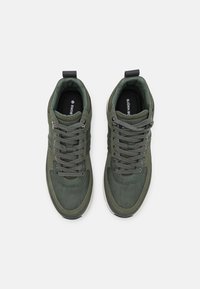 Groene suède hoge sneakers met grijze veters, gevoerde kraag en contrasterende witte rubberen zool. Logo zichtbaar op de tong.