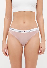 Tommy Hilfiger rozā svītrainas bikini apakšbikses ar baltu elastīgu jostu, kas rotāta ar melno logotipa tekstu. Izgatavotas no mīkstas, stiepjamas auduma.
