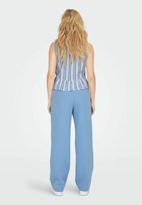 Sinine ja valge rihmadega ilma varrukateta tops peplum taljega, koos vabade helesiniste pükstega. Riietuse lõpetavad valged tossud.
