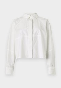 White cropped shirt made of cotton. Features a classic collar, long sleeves with buttoned cuffs, and subtle seam detailing.