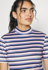 Top de gola alta às riscas com mangas curtas; apresenta riscas em azul-marinho, rosa e azul-claro; feito de um material liso e elástico.