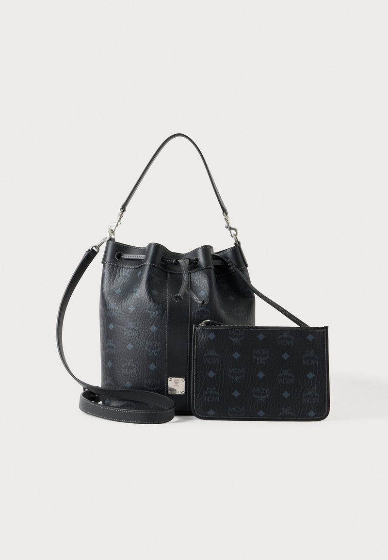 Sac seau en cuir noir avec bandoulière réglable et pochette zippée assortie avec un motif de logo discret sur fond blanc.
