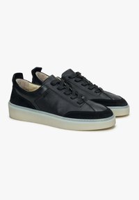 Czarne skórzane i zamszowe sneakersy o niskim profilu, okrągłym nosku, tonowych sznurowadłach i jasnej gumowej podeszwie. Minimalistyczne detale i akcenty.