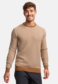 Gestreifter Strickpullover in Braun und Creme mit rundem Halsausschnitt und gerippten Bündchen, aus strukturiertem Material gefertigt und in lockerem Schnitt.