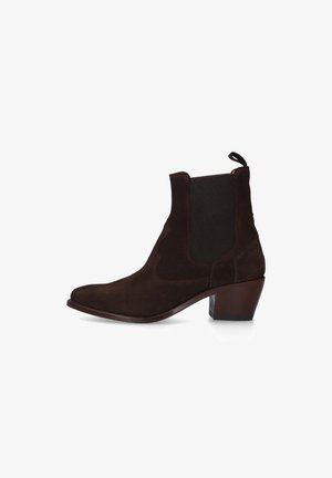 Donkerbruine suède enkellaarzen met elastische zijpanelen, aantreklipje, spits toelopende neus en blokhak op witte achtergrond.