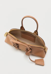 Brown leather handbag with a gold zipper, top handles, and a keychain. The interior features card slots and a smooth beige lining.
