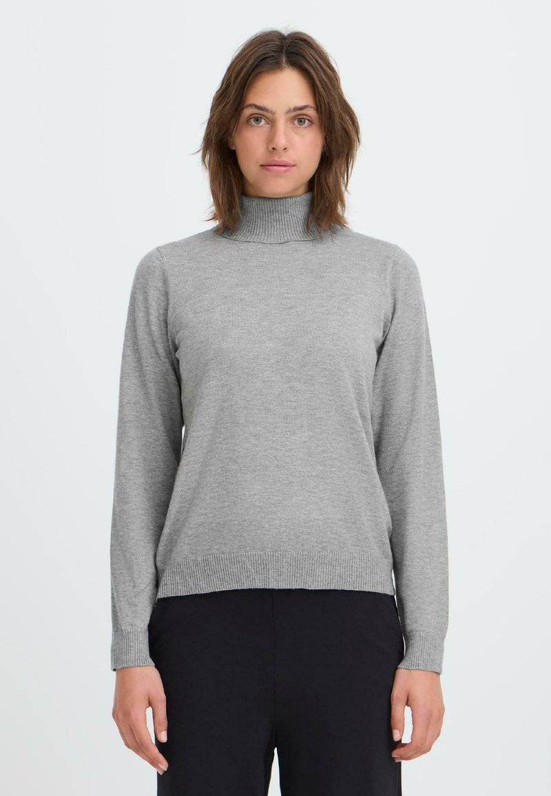 Grauer Rollkragenpullover aus weichem Strickmaterial, mit langen Ärmeln und gerippten Säumen, kombiniert mit dunklen Hosen.