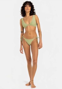 Light green bikini set with a triangular top and side-tie bottom. Smooth texture, minimalist design, and adjustable ties.