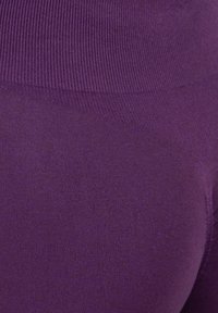Lila Leggings aus glattem, dehnbarem Stoff mit einem breiten gerippten Bund. Die Oberfläche ist einheitlich ohne sichtbare Muster oder Akzente.