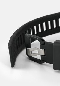 Schwarzes Silikon-Uhrenarmband mit strukturiertem Muster, Metallverschluss mit Stift und Zugmechanismus sowie Belüftungsschlitzen für Atmungsaktivität.