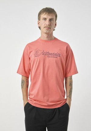 Kariertes T-Shirt mit kurzen Ärmeln aus Baumwolle. Mit einem bedruckten Logo und einer Illustration in dunklerer Farbe. Lockerer Schnitt mit rundem Halsausschnitt.