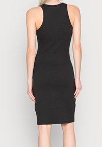 Czarna dopasowana sukienka na ramiączkach, do kolan, ze żebrowanym wzorem, bez rękawów, z okrągłym dekoltem, gładka tkanina, prosta i minimalistyczna stylizacja.