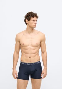 Boxers azuis-marinho com mistura suave de algodão, cintura elástica com marca e design ajustado, textura suave.
