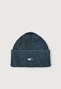 Ribidega kudum müts kahes erinevas sinises toonis, käärkuvalt servaga ning esiküljel on ristkülikukujuline "Tommy Jeans" logo patch.